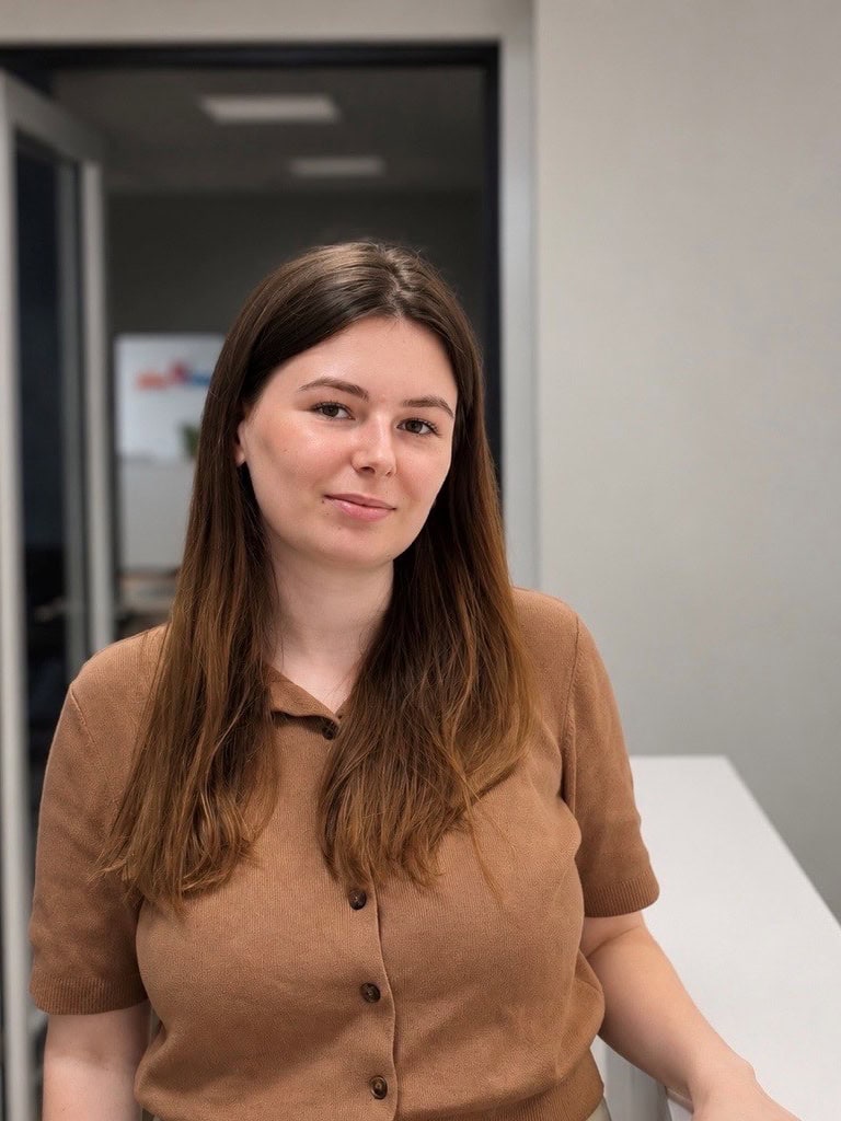 Junge Frau im braunen Poloshirt in modernem Büro